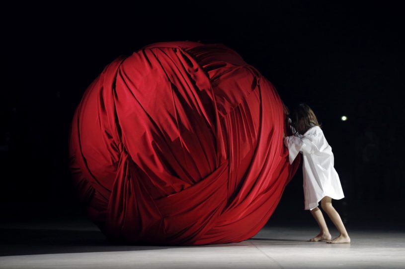 A young girl pushes a giant ball made of fabric during Jacquemus' fashion show during the 2016 Spring/Summer ready-to-wear collection, on September 29, 2015 in Paris.  AFP PHOTO / FRANCOIS GUILLOT        (Photo credit should read FRANCOIS GUILLOT/AFP/Getty Images)